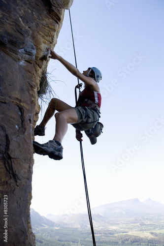 Photo: A climber climbing a rock face A climber climbing a rock face
