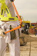 Photo: Mid section view of a female construction worker cutting an iron rod with a bolt cutter Mid section view of a female construction worker cutting an iron rod with a bolt cutter