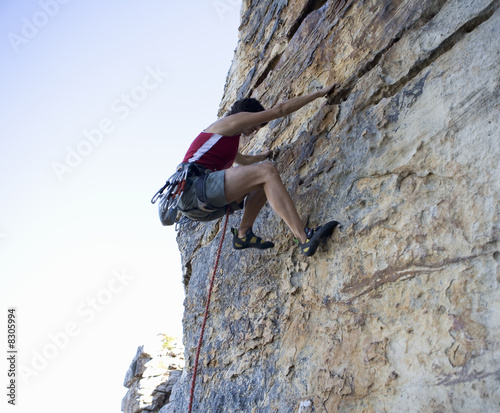 Photo: A climber climbing a rock face A climber climbing a rock face