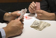 Close-up of businessmen playing cards for money