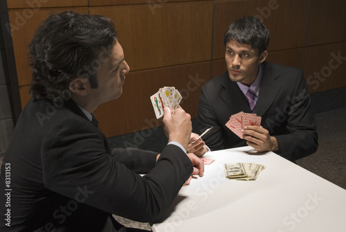 Photo: Businessmen playing cards for money Businessmen playing cards for money