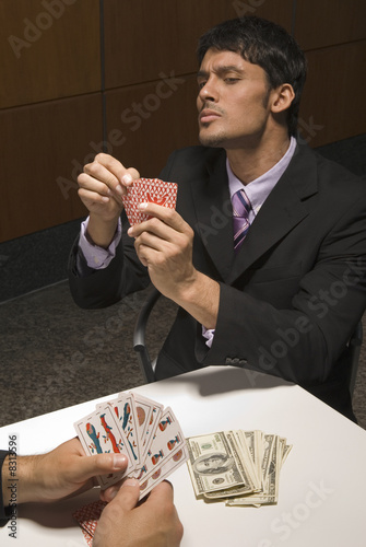 Photo: Businessmen playing cards for money Businessmen playing cards for money