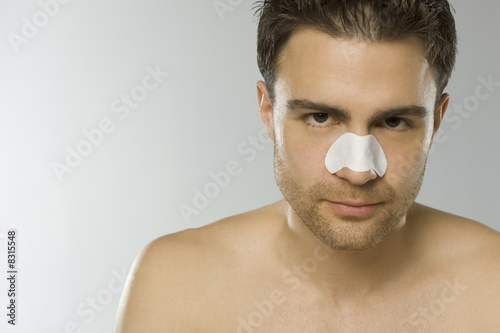 Foto: Young adult man using nasal strip, portrait Young adult man using nasal strip, portrait