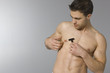 Young man shaving his chest