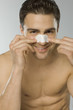Young adult man using nasal strip, portrait