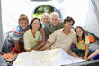 Photo: Multi-generational family sitting inside tent on camping trip, looking at map, smiling, portrait Multi-generational family sitting inside tent on camping trip, looking at map, smiling, portrait
