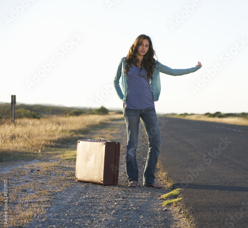 Photo: A woman with a suitcase hitching a lift A woman with a suitcase hitching a lift