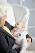 A grandmother holding her new grandchild