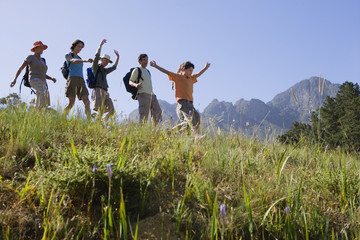 Photo: Multi-generational family hiking on mountain trail, walking in line, boy (9-11) leading, side view Multi-generational family hiking on mountain trail, walking in line, boy (9-11) leading, side view