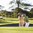Man teaching a woman how to play golf