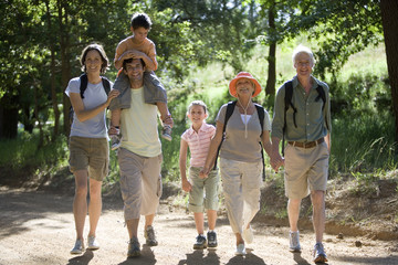 Photo: Multi-generational family hiking on woodland trail, boy (8-10) on father's shoulders, smiling, portrait Multi-generational family hiking on woodland trail, boy (8-10) on father's shoulders, smiling, portrait