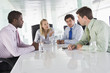 Four businesspeople in a boardroom talking