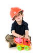 Child  with hard hat playng sitting on the floor