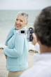 Foto: A senior man filming his partner on a video camera A senior man filming his partner on a video camera