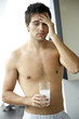 Young man drinking a hangover remedy