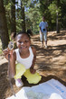 Photo: Girl (7-9) kneeling on woodland trail, looking at map, using compass, smiling, portrait, brother (8-10) in background Girl (7-9) kneeling on woodland trail, looking at map, using compass, smiling, portrait, brother (8-10) in background