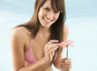 A young woman in a bikini holding a flower