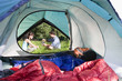 Photo: Tent interior view of couple sitting outside on grass, pouring water from hot kettle Tent interior view of couple sitting outside on grass, pouring water from hot kettle
