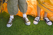 Photo: Brother and sister (8-10) assembling dome tent on garden lawn, standing beside orange outer tent canvas, low section, close-up, front view Brother and sister (8-10) assembling dome tent on garden lawn, standing beside orange outer tent canvas, low section, close-up, front view