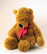 Cuddly love teddy bear with red bow on