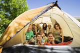 Photo: Three generation family lying, sitting and kneeling inside tent on garden lawn, smiling, front view, portrait Three generation family lying, sitting and kneeling inside tent on garden lawn, smiling, front view, portrait