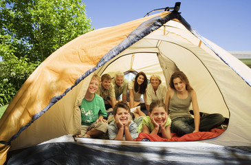 Photo: Three generation family lying, sitting and kneeling inside tent on garden lawn, smiling, front view, portrait Three generation family lying, sitting and kneeling inside tent on garden lawn, smiling, front view, portrait