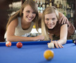 Two teenage girls playing pool