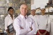 Photo: Proud restaurant manager standing with waitress and chefs near commercial kitchen, smiling, portrait Proud restaurant manager standing with waitress and chefs near commercial kitchen, smiling, portrait