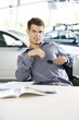 A young man with keys to a new car