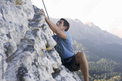 Photo: A climber climbing a rock face A climber climbing a rock face