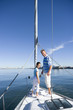 Photo: Father and daughter (8-10) standing at bow of sailing boat, smiling, side view, portrait Father and daughter (8-10) standing at bow of sailing boat, smiling, side view, portrait