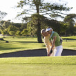 Man teaching a woman how to play golf