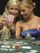 Women looking at playing cards at poker game