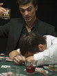 Upset man with head down at poker game
