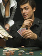 Man at poker game with woman holding cash