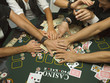 Detail of arms reaching for money at poker game