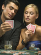 Couple looking at playing cards at poker game