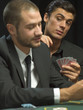 Man looking over man's shoulder during poker game