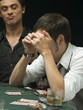 Worried man looking at playing cards at poker game