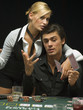 Couple throwing playing cards at poker game