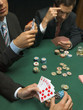 Detail of men holding playing cards at poker game