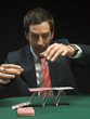 Man building house with playing cards