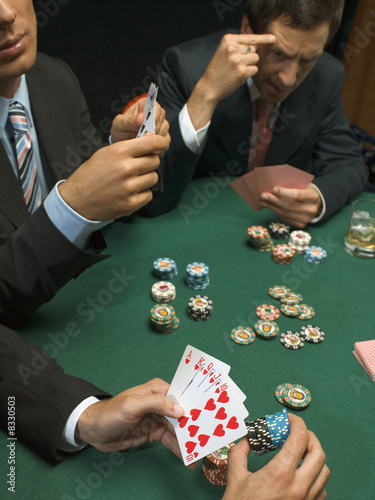 Photo: Detail of men holding playing cards at poker game Detail of men holding playing cards at poker game