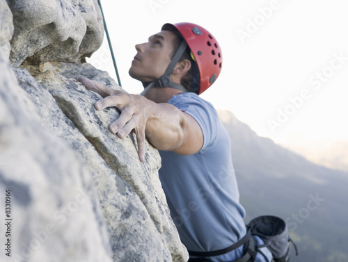 Photo: A climber climbing a rock face A climber climbing a rock face