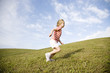 A young girl running across a hill