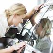 A young woman admiring a new car