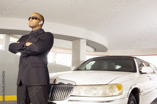 Photo: A chauffer standing by a stretch limousine A chauffer standing by a stretch limousine