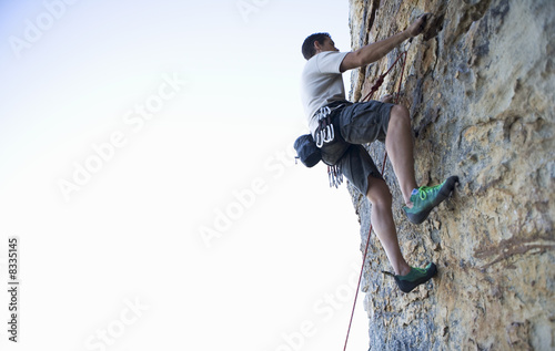 Photo: A climber climbing a rock face A climber climbing a rock face