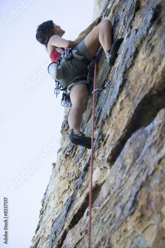 Photo: A climber climbing a rock face A climber climbing a rock face