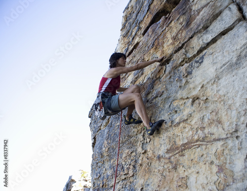 Photo: A climber climbing a rock face A climber climbing a rock face